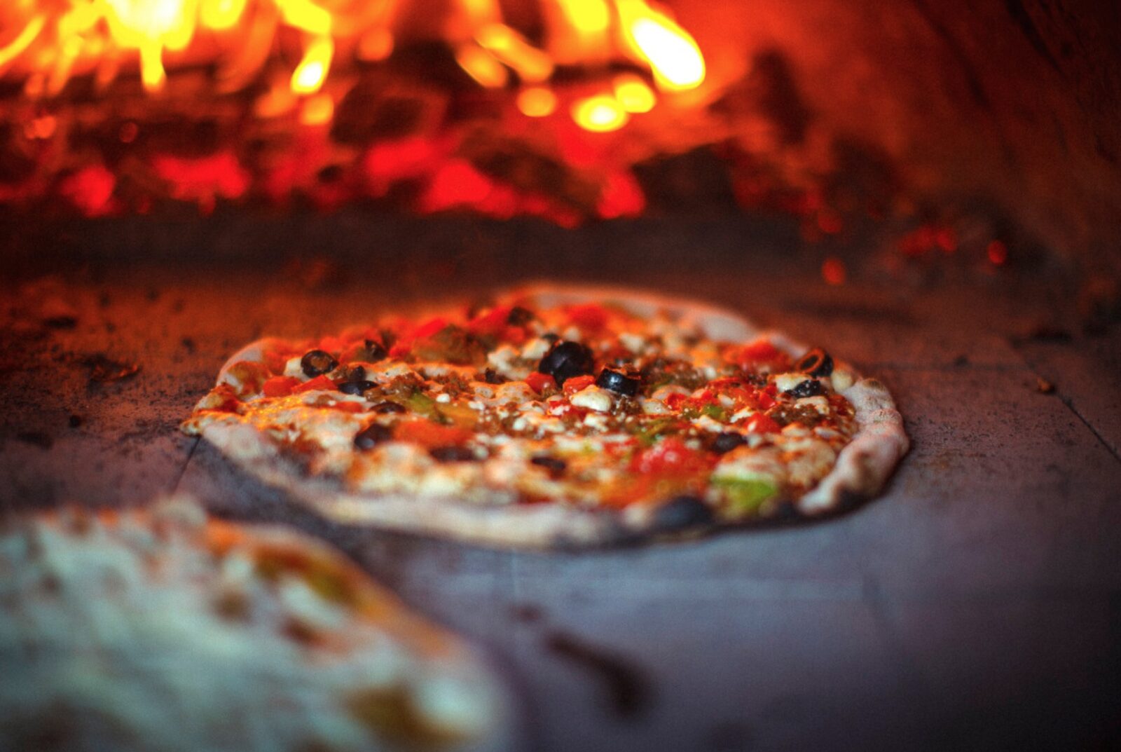 Fresh pizza cooking in the wood-fired oven